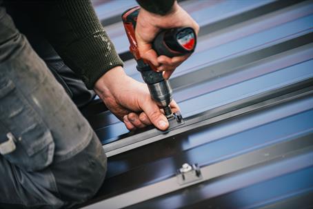 roofer working on a metal roof