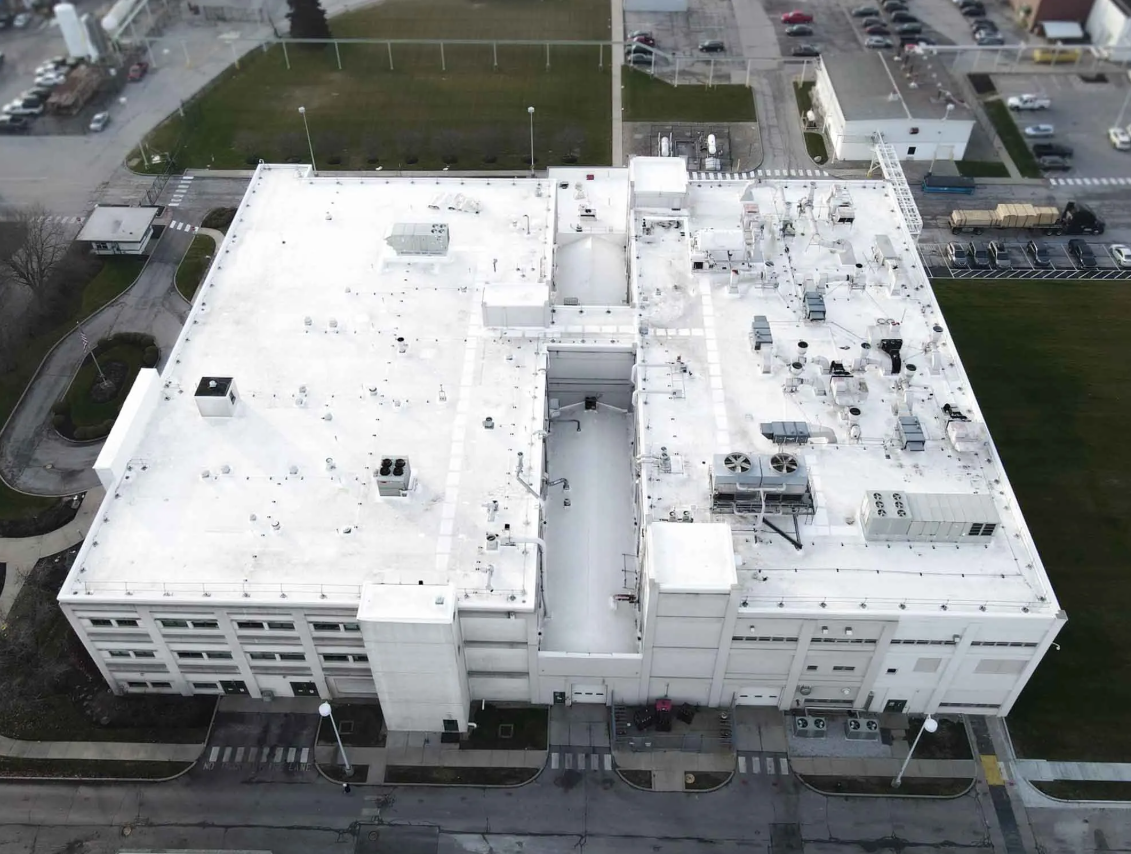 Aerial view of a industrial building's roof restored by Seamless Roofing